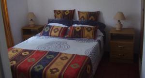 a bedroom with a bed and two nightstands with two lamps at Aguada Chica Bungalows in Villa Carlos Paz
