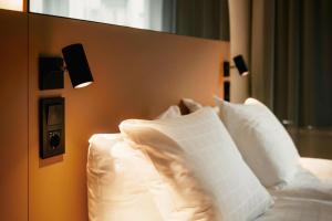 ein Schlafzimmer mit einem Bett mit weißen Kissen in der Unterkunft Scandic Go, Sankt Eriksgatan 20 in Stockholm