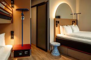 ein Hotelzimmer mit einem Bett und einem kleinen Hocker in der Unterkunft Scandic Go, Sankt Eriksgatan 20 in Stockholm