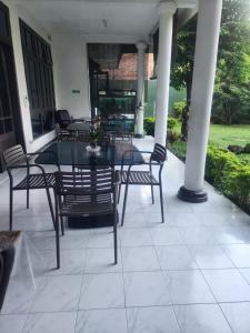 a patio with a table and chairs on a porch at Wisma Pakuan Syariah Hotel in Bogor