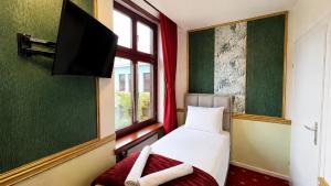 a bedroom with a bed and a tv and a window at Hotel Viki in Vienna
