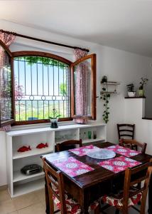 a dining room with a table and chairs and a window at Casa Maddalena in Monteriggioni +6 photos