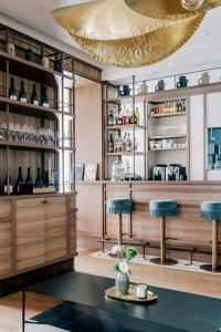 a restaurant with blue stools and a gold ceiling at Les Bassans - Fontenille Collection in Perros-Guirec