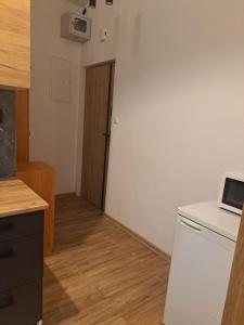 a kitchen with a white refrigerator and a door at Lunar Apartament in Augustów