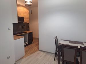 a kitchen and dining room with a table and chairs at Lunar Apartament in Augustów