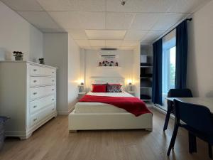 a bedroom with a bed with a red blanket and a table at Appartement 1 - OUEST in Rimouski