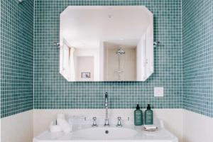 a bathroom with a sink and a mirror at Les Bassans - Fontenille Collection in Perros-Guirec