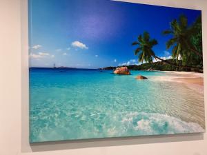 a painting of a beach with palm trees and the ocean at Appartement 1 - OUEST in Rimouski