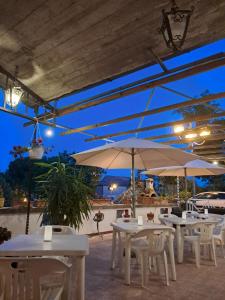 a group of tables and chairs with umbrellas at Albergo Ristorante Il Torrione in Auditore