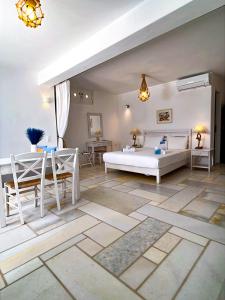a bedroom with a bed and a table and chairs at White Blue Houses & Apartments Paros in Parikia
