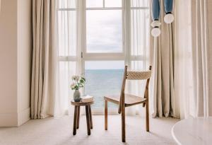 a chair in front of a window with the ocean at Les Bassans - Fontenille Collection in Perros-Guirec +56 photos