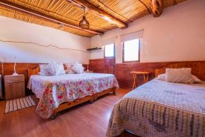 a bedroom with two beds and a window at Hotel-Camping Takha Takha in San Pedro de Atacama
