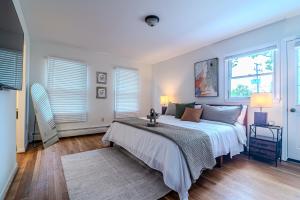 a bedroom with a large bed and two windows at Arlington Suite in Arlington