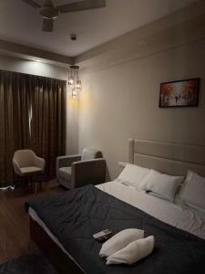 a bedroom with a bed and a couch and a chair at CasaVerve stay in Greater Noida
