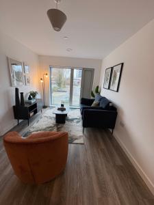 a living room with a couch and a chair at Modern 2BD 2 bathroom apartment close to city centre in Manchester