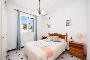 a bedroom with a bed and a window at Villa Emilio in Cala en Porter +7 photos