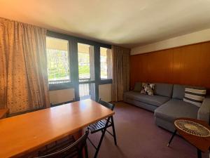 a living room with a table and a couch at Monolocale Des Alpes 204 in Madonna di Campiglio