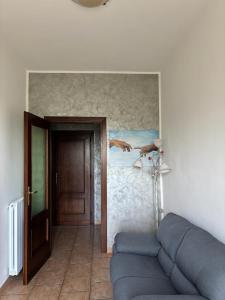 a living room with a couch and a painting on the wall at Casa Ciccone-L'Aquila in Tornimparte