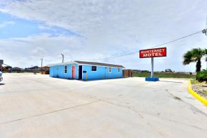 a street sign in front of a blue motel at Monterrey Motel Padre Island, Corpus Christi BY OYO in Padre Island