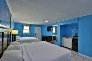 a blue room with two beds and a sink at Monterrey Motel Padre Island, Corpus Christi BY OYO in Padre Island +24 photos