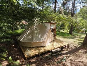 a tent on a wooden platform in the woods at La Ramie in Marat