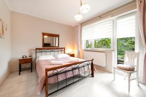 a bedroom with a bed and a large window at Wenge in Jastarnia