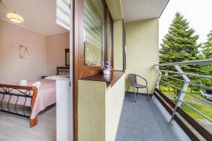 a room with a bed and a balcony at Wenge in Jastarnia