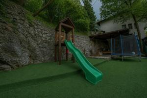 a playground with a green slide in a yard at Guest House LIKE in Sarajevo