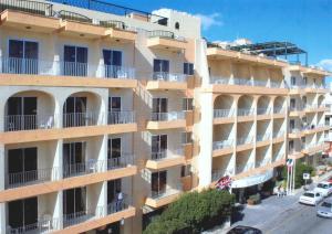 an apartment building with balconies and a street at Soreda Hotel in St. Paul's Bay