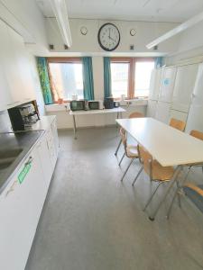 a kitchen with a table and chairs and a clock on the wall at Office House Tripla in Helsinki