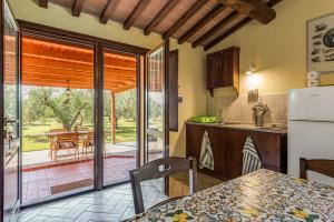a kitchen with a refrigerator and a table and a patio at Agriturismo Il Pescinone in Venturina Terme