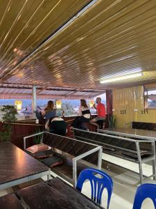 a restaurant with tables and chairs and people sitting at Rock Backpackers Central Hostel in Vang Vieng