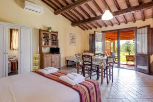 a bedroom with a bed and a table and chairs at Agriturismo Il Pescinone in Venturina Terme