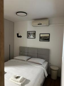 a bedroom with a white bed with a white blanket at Apartments Bubalo in Omiš +31 photos
