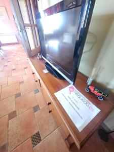 a large flat screen tv sitting on top of a wooden stand at MEQUEDO el ESPOLON in Alcañiz