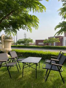a group of picnic tables and chairs in the grass at Global properties in Faisalabad