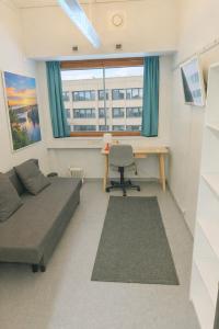 a small room with a bed and a desk and a desk at Office House Tripla in Helsinki