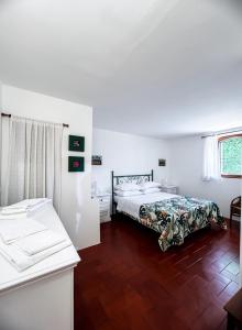 a white bedroom with a bed and a desk and a window at Casa Maddalena in Monteriggioni