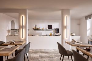 a restaurant with wooden tables and chairs and a kitchen at Hotel Adonis in Mikonos