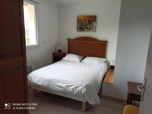 a bedroom with a bed with white sheets and a window at Ramier in Giverny