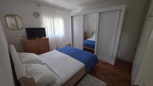 a small bedroom with a bed and a television at Apartments MiMa in Kotor