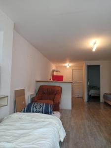a living room with a couch and a bed at Appartement entier in Montmarault