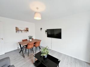 a living room with a dining table and a flat screen tv at The Easter Suites with free parking in Edinburgh