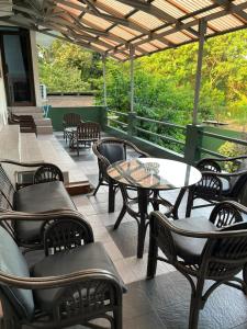 a patio with tables and chairs on a porch at Wisma Pakuan Syariah Hotel in Bogor