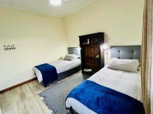 a hotel room with two beds and a mirror at Pleasance Flat nr 8A Worcester Street in Grahamstown