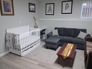a living room with a couch and a crib at Cozy in London