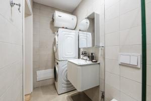 a small bathroom with a refrigerator and a sink at NooN Apartment | Sofo Duni by PikHost in Dhërmi +33 photos