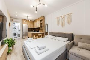 a bedroom with a large white bed and a couch at NooN Apartment | Sofo Duni by PikHost in Dhërmi