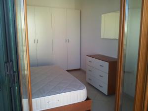 a bedroom with a bed and a dresser and a mirror at Il Ventaglio Apartment in Martinsicuro