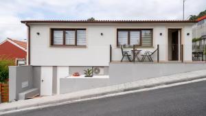 a white house with a table and chairs on a street at Terraza del atardecer in Vilar